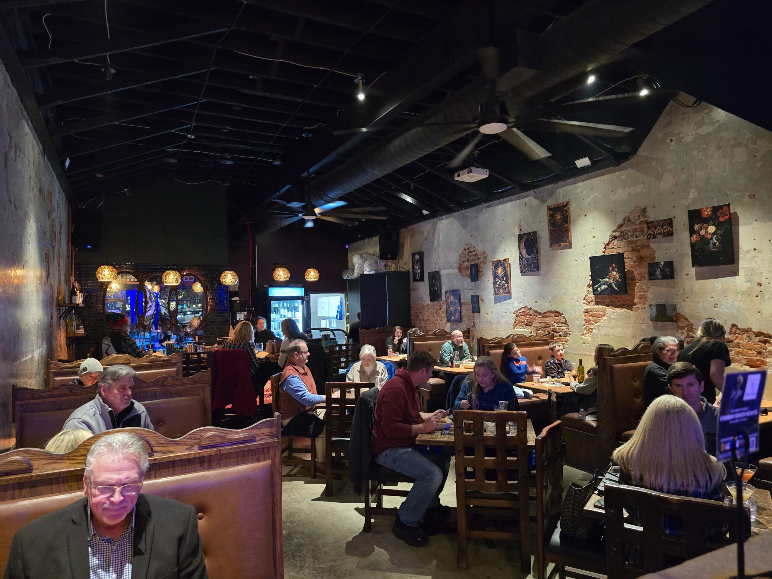 Inside view of Sanctuary on the Square restaurant with guests sitting at tables and the bar